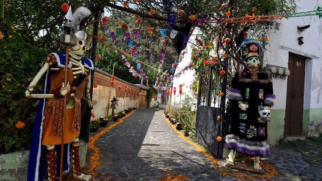 Calle de Malinalco adornada con guerreros de Día de Muertos, cempasúchil y papel picado